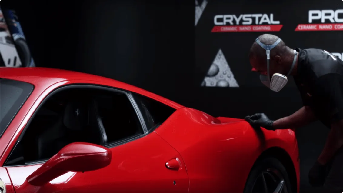 Professional applying ceramic nano coating to red sports car