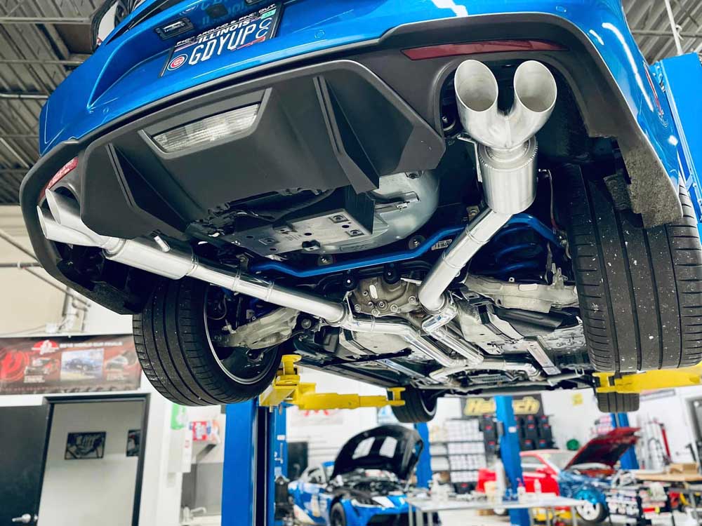 Custom dual-tip rear exhaust on a finished blue performance car