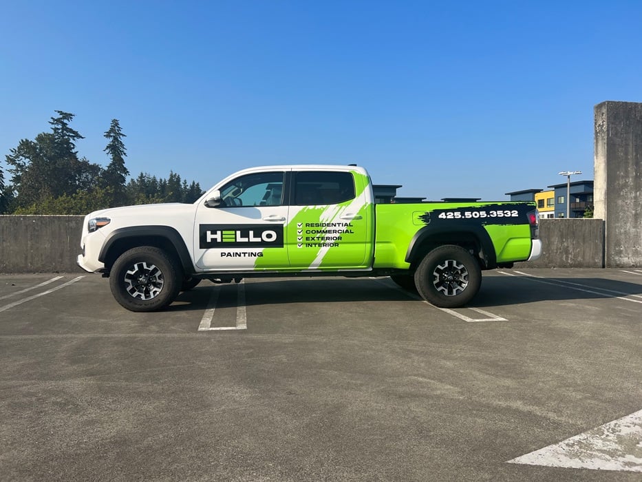 White and green Hello Painting fleet truck wrap parked in lot