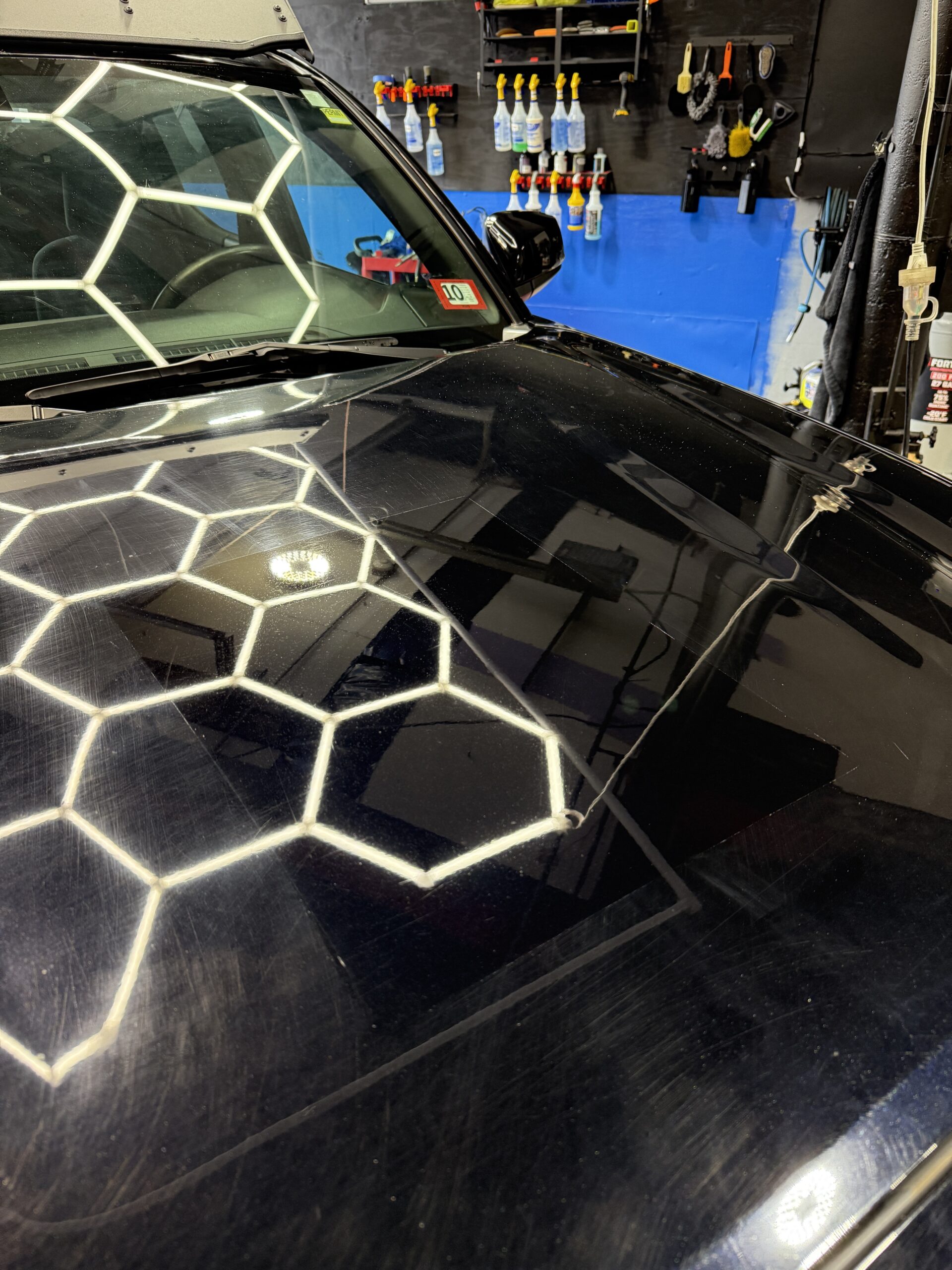 Professional detailer applying ceramic coating to vehicle