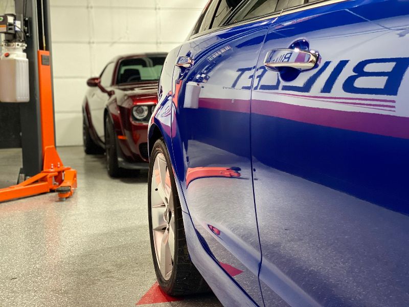 Technician applying protective film to vehicle