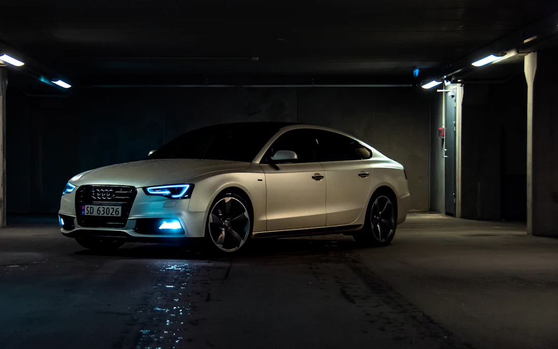 Silver luxury sedan in a tunnel, catching light across its metallic panels