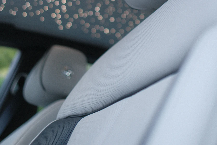 Luxury car interior cabin viewed from inside, showing the headliner fabric and ceiling